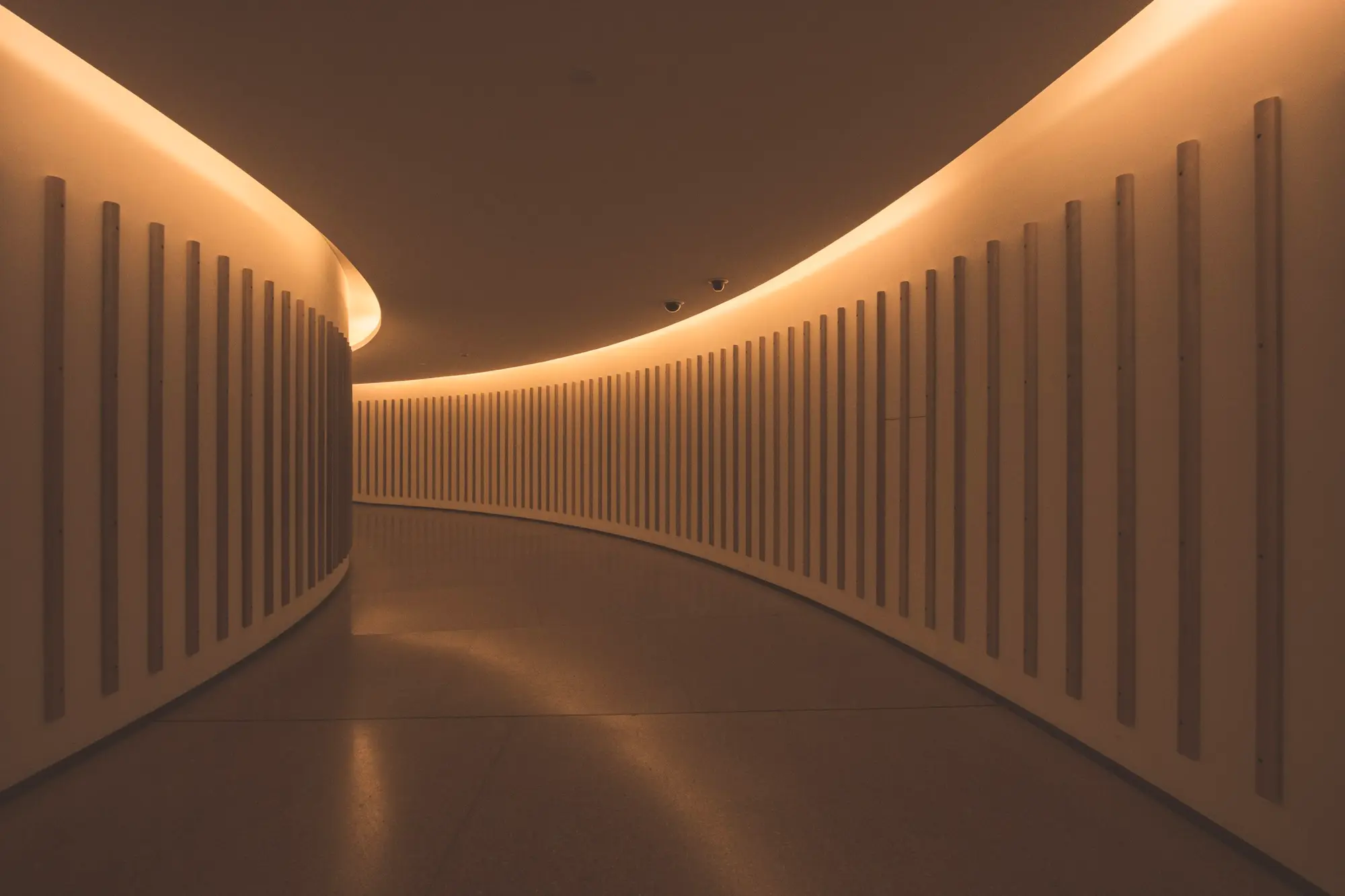 A curved corridor washed in warm indirect light