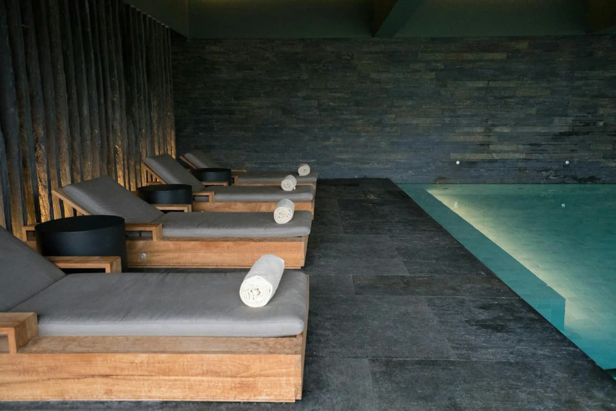 Loungers beside a dark indoor pool
