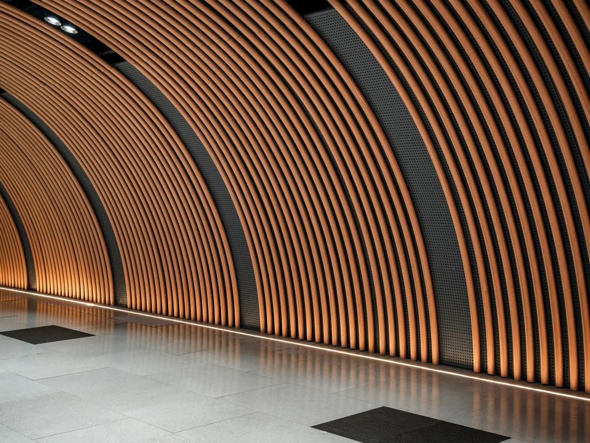 Curved timber slats forming a softly lit arched passage