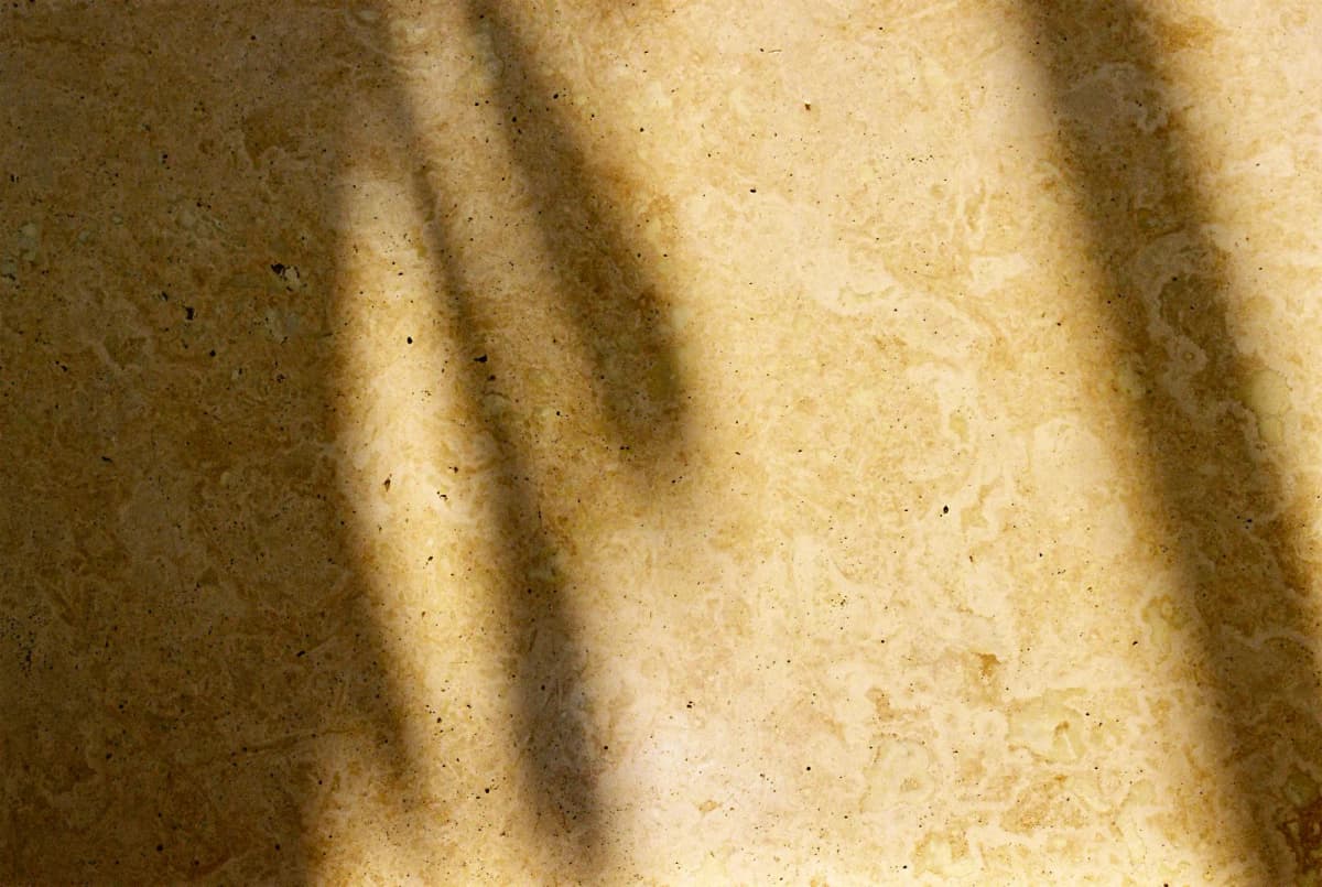 Window shadows across a cream travertine floor